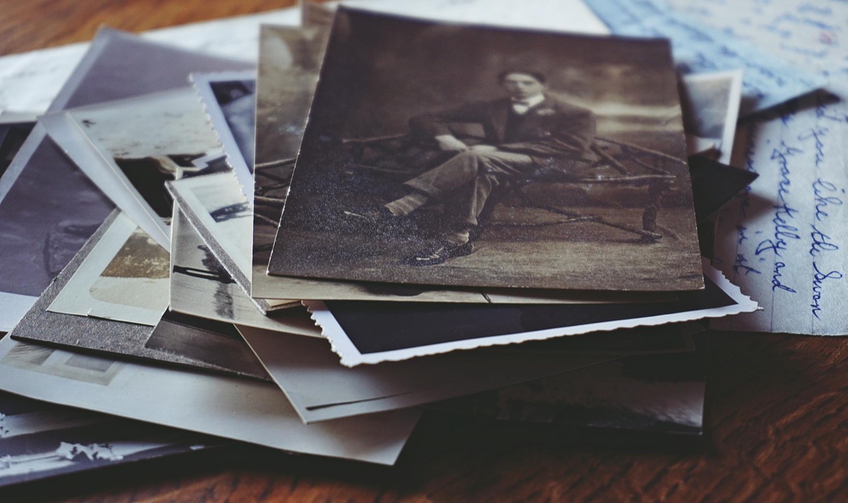 A formal period portrait among handwritten letters and old photographs