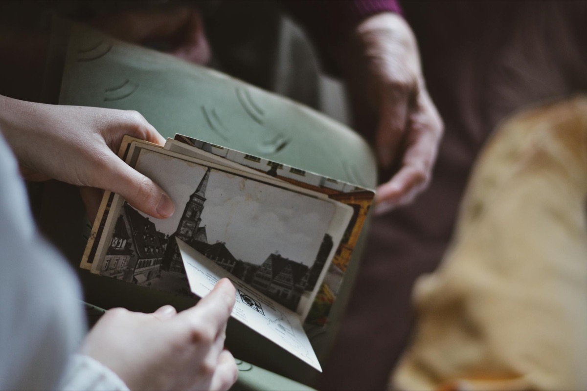 Two people passing a vintage family photograph between them